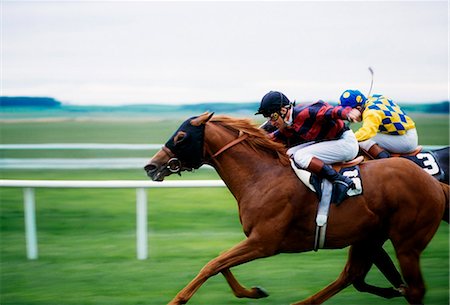 fantino (uomo e donna) - Horse Racing; Two Horses Neck In Neck During A Horse Race Fotografie stock - Rights-Managed, Codice: 832-03639914