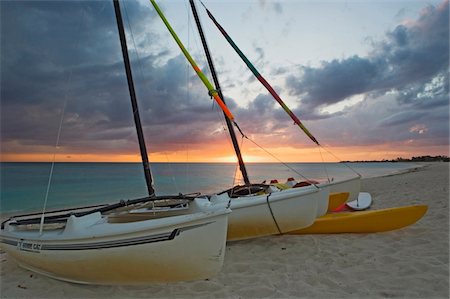 Sunset at Playa Ancon beach near Trinidad with beached sail boats in the foreground. Foto de stock - Con derechos protegidos, Código: 832-03724129