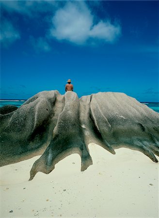 seychelles - View of woman from back sitting on rocks at the beach Foto de stock - Con derechos protegidos, Código: 832-03724384