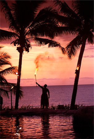 fiji grass skirts - Native in a grass skirt holding a flaming torch by coast at sunset Stock Photo - Rights-Managed, Code: 832-03724602