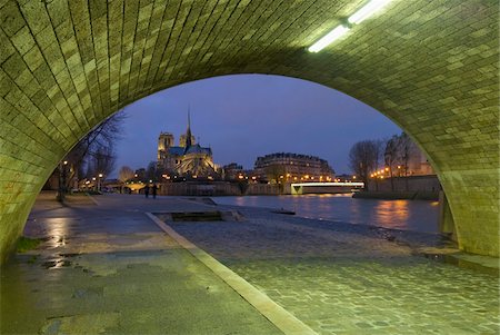 french bridge - Archway under bridge looking towards Notre Dame cathedral at dusk. Stock Photo - Rights-Managed, Code: 832-03724775