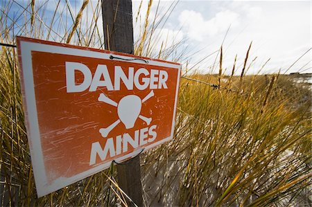 Signs on beach on East Falkland warning of dangers of unexploded mines and mine fields Foto de stock - Con derechos protegidos, Código: 832-03724968