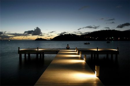 Woman sitting on end of pier at dusk Stock Photo - Rights-Managed, Code: 832-03723678