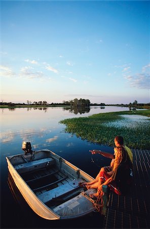 pantano - Couple sitting on pier beside boat in Yellow Water wetlands, Foto de stock - Con derechos protegidos, Código: 832-03723958