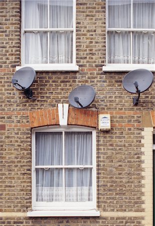 sistema británico - brick terrace, three satellite dishes and alarm. Shoreditch Foto de stock - Con derechos protegidos, Código: 845-04827099