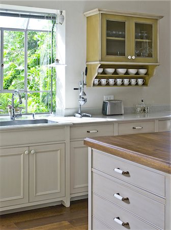 Wall mounted kitchen cabinet next to sink at window. Ramhash Munjak, Israel. Stock Photo - Rights-Managed, Code: 845-05837861