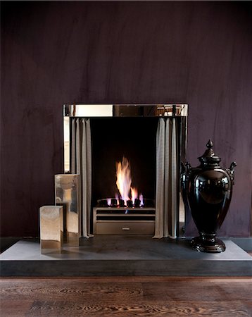 detail of fireplace in the inside of a home - Lit fire with black urn, Addison Road, UK. Stock Photo - Rights-Managed, Code: 845-05838109