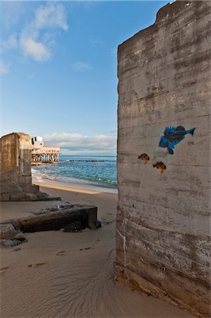 View between old concrete walls on beach, with blue and orange fish graffiti, with Pacific Ocean and pier in the background - Monterey, California. Stock Photo - Rights-Managed, Code: 845-05838334