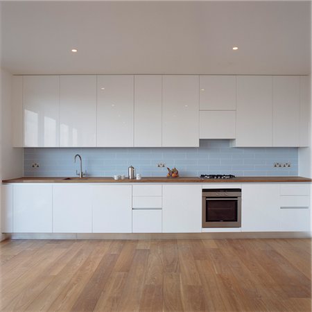 Kitchen with white cupboard units and wooden floor Stock Photo - Rights-Managed, Code: 845-05838842