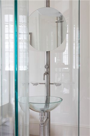 Round mirror above glass washbasin in modern bathroom Stock Photo - Rights-Managed, Code: 845-05838853