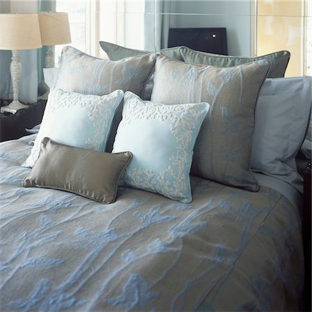 Double bed with beige and blue bedcover and cushions in front of mirror. Stock Photo - Rights-Managed, Code: 845-05838876