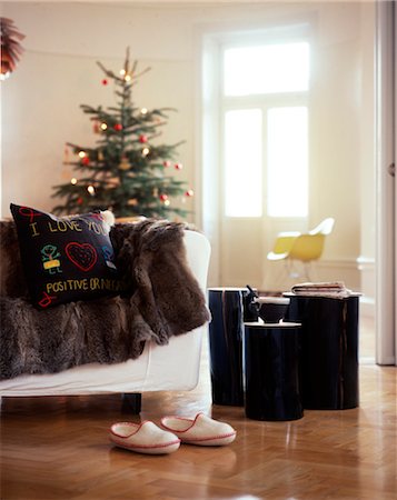 Pair of slippers in room with Christmas tree and fur rug over sofa. Foto de stock - Con derechos protegidos, Código: 845-05839311