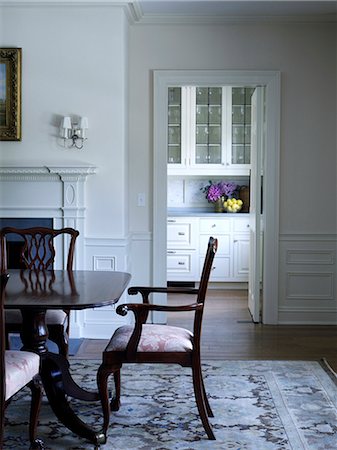 Dark wood dining chair at table on patterned rug in Shelley Morris Designed Colonial style residence in New Canaan, Connecticut, USA Foto de stock - Con derechos protegidos, Código: 845-07561503