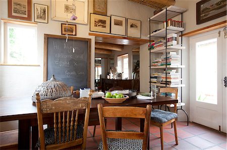 Kitchen dining table with blackboard message, antique chairs and artwork in South African home Stockbilder - Lizenzpflichtiges, Bildnummer: 845-07584977