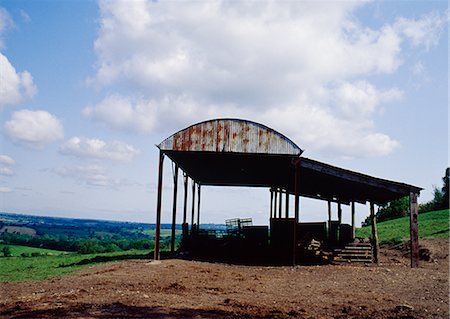 simsearch:600-02886688,k - Semi-derelict corrugated iron barn silhouetted against view of countryside, rusting. near Bruton, Somerset. Stock Photo - Rights-Managed, Code: 845-02729343