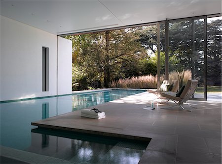 Ad Astra. L-shaped interior-exterior swimming pool with picture window and view to garden. Architects: Munkenbeck and Marshall Foto de stock - Con derechos protegidos, Código: 845-03777234