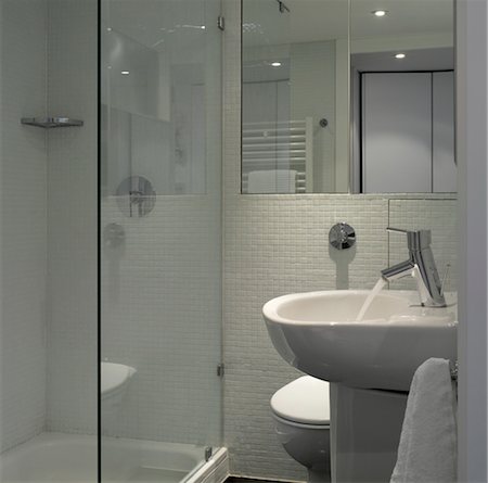 Pedestal basin, toilet and glass shower door in compact white bathroom. Architects: Openstudio Foto de stock - Con derechos protegidos, Código: 845-03777249