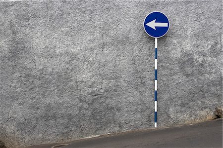 simsearch:845-03777421,k - Madeira. White One way sign on blue background against stone wall Stock Photo - Rights-Managed, Code: 845-03777426