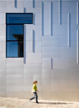 simsearch:845-05837740,k - Female figure walking past the cladded facade of Cornerstone Arts Centre, Didcot. Architects: Ellis Williams Architects Stock Photo - Rights-Managed, Code: 845-03777447