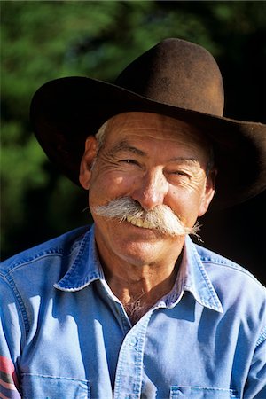 seniors storytelling - 1990s PORTRAIT OF SMILING COWBOY WITH GRAY MUSTACHE BLACK HAT BLUE SHIRT LOOKING AT CAMERA Stock Photo - Rights-Managed, Code: 846-05645815