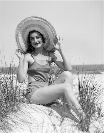 simsearch:846-03165734,k - 1920s - 1930 SMILING BATHING BEAUTY WEARING STRAW HAT SITTING ON BEACH SAND DUNE LOOKING AT CAMERA Stock Photo - Rights-Managed, Code: 846-05645937