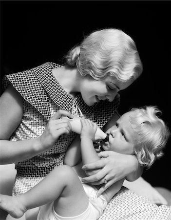 simsearch:846-06111790,k - 1930s BLONDE WOMAN MOTHER SMILING FEEDING BABY BOTTLE Stock Photo - Rights-Managed, Code: 846-05645962