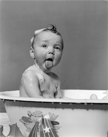 1940s WET BABY IN BATH COVERED WITH SOAP SUDS STICKING OUT TONGUE Stock Photo - Rights-Managed, Code: 846-05645993