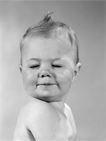 simsearch:846-05646010,k - 1960s SIDE VIEW OF PORTRAIT BABY WITH CHIN ON SHOULDER & CLOSED EYES SMIRKING TURNING HEAD TOWARD CAMERA Foto de stock - Direito Controlado, Número: 846-05646037