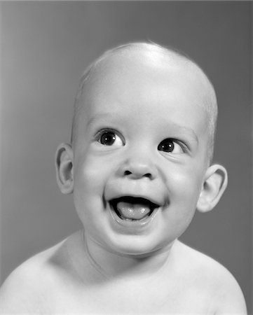 1960s CLOSE-UP PORTRAIT OF NEARLY BALD BABY SMILING WITH MOUTH WIDE OPEN LOOKING OFF TO THE SIDE Stock Photo - Rights-Managed, Code: 846-05646031