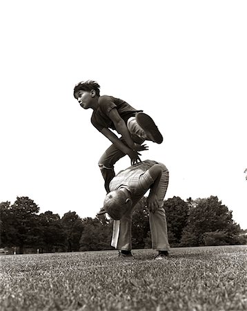 retro friendship - PAIRE DES ANNÉES 1970 DES GARÇONS À L'EXTÉRIEUR EN JOUANT À SAUTE-MOUTON SUR LE TERRAIN Photographie de stock - Rights-Managed, Code: 846-05646070