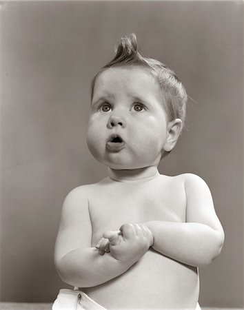 funny care - 1950s WORRIED BABY LOOKING UP UNCERTAIN WITH CLASPED HANDS STUDIO Stock Photo - Rights-Managed, Code: 846-05646082
