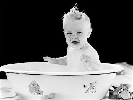 1930s - 1940s SMILING HAPPY BABY SITTING IN ENAMELED TIN BATHTUB Foto de stock - Con derechos protegidos, Código: 846-05646149