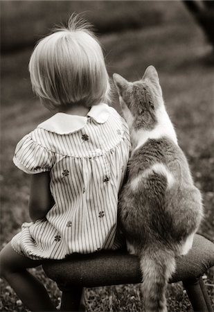 1980s REAR VIEW OF LITTLE GIRL & CAT SITTING OUTSIDE ON STOOL Foto de stock - Con derechos protegidos, Código: 846-05646183