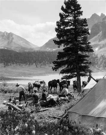 simsearch:846-03163984,k - ANNÉES 1920 - ANNÉES 1930 GROUPE HOMMES FEMMES CAMPING DANS DES TENTES CHEVAUX AVEC TRAIN D'ÉQUITATION DANS LES MONTAGNES DE FOND ASSINIBOINE CANADA Photographie de stock - Rights-Managed, Code: 846-05646201