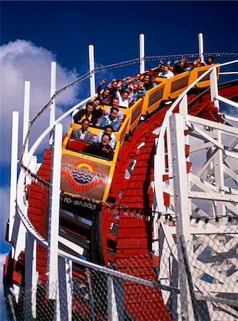 simsearch:846-05647820,k - 1970s - 1980s ROLLER COASTER COMING AROUND DOWNHILL CURVE RIDERS SCREAMING Stock Photo - Rights-Managed, Code: 846-05646239