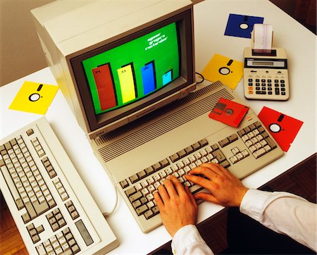 1980s MALE HANDS ON COMPUTER KEYBOARD WITH MONITOR FLOPPY DISKS CALCULATOR Stock Photo - Rights-Managed, Code: 846-05646245