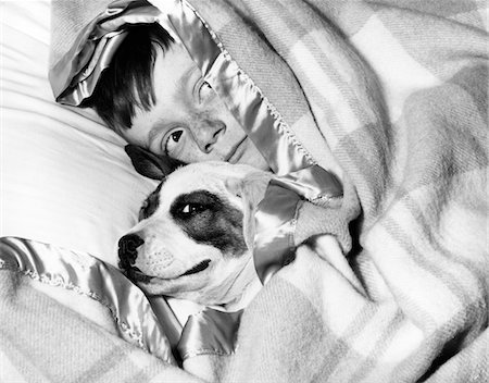 simsearch:846-03163283,k - ANNÉES 1950 BOY SE CACHER SOUS LA COUVERTURE AU LIT AVEC CHIEN Photographie de stock - Rights-Managed, Code: 846-05646269