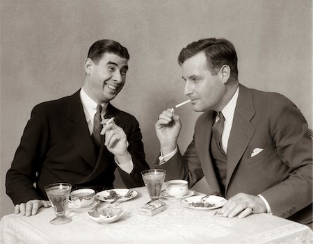 1930s TWO MEN LIGHTING AFTER DINNER CIGARETTES SMILING Foto de stock - Con derechos protegidos, Código: 846-05646286