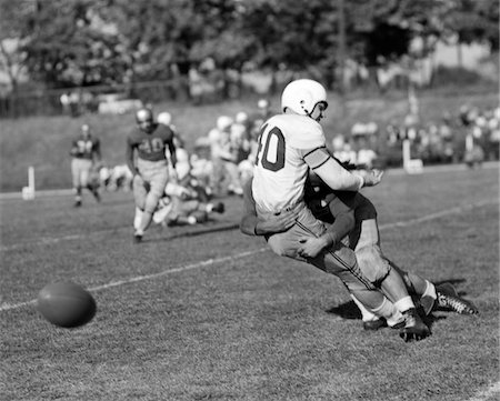 simsearch:846-06111784,k - 1950s COLLEGE FOOTBALL GAME ONE PLAYER TACKLING ANOTHER FUMBLE Stock Photo - Rights-Managed, Code: 846-05646333