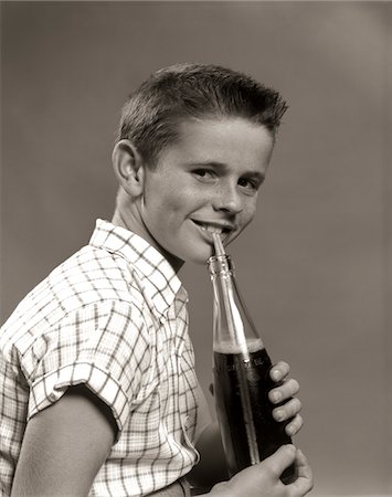softdrink - 1950s SMILING BOY DRINKING CARBONATED BEVERAGE FROM SODA POP BOTTLE WITH STRAW Stock Photo - Rights-Managed, Code: 846-05646352