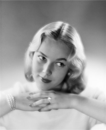 portraits profile shots - 1950s PRETTY BLOND WOMAN CHIN RESTING ON HANDS LOOKING OFF TO THE SIDE Stock Photo - Rights-Managed, Code: 846-05646396