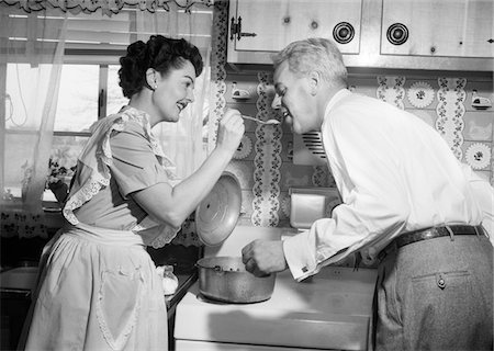 simsearch:846-06111889,k - 1950s HOUSEWIFE IN KITCHEN HAVING HUSBAND TASTE FOOD ON STOVE Stock Photo - Rights-Managed, Code: 846-05646444