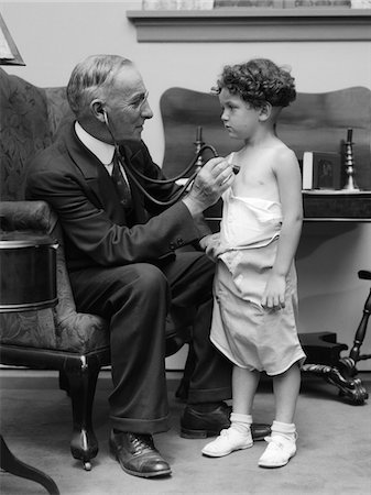 simsearch:846-06111944,k - 1930s MAN DOCTOR MAKING HOUSE CALL HOLDING STETHOSCOPE TO CHEST OF LITTLE BOY PATIENT Stock Photo - Rights-Managed, Code: 846-05646530