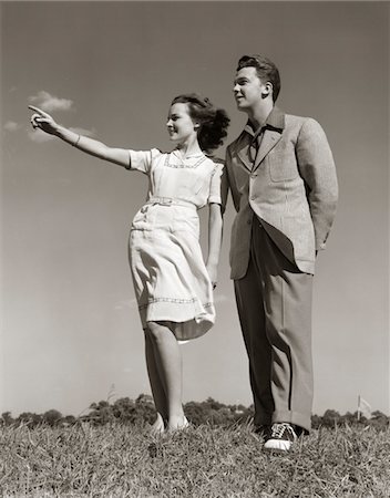 simsearch:846-05646579,k - ANNÉES 1940 TEENAGE COUPLE DEBOUT DEHORS ENSEMBLE FILLE POINTANT Photographie de stock - Rights-Managed, Code: 846-05646559