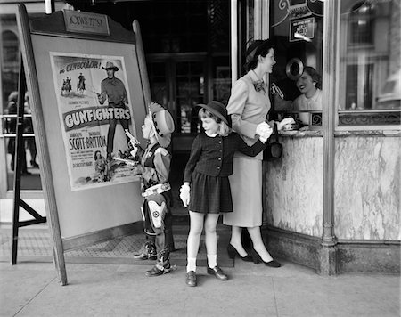 family movies - DES ANNÉES 1950 MÈRE DE 2 ENFANTS ACHETER DES BILLETS À MOVIE MATINEE GARÇON PORTANT COSTUME DE COWBOY Photographie de stock - Rights-Managed, Code: 846-05646551