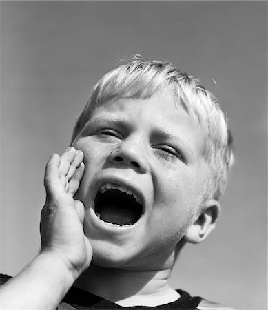 1950s BLOND BOY WITH EYES CLOSED AND HAND CUPPING A WIDE OPEN MOUTH SHOUTING Foto de stock - Con derechos protegidos, Código: 846-05646552