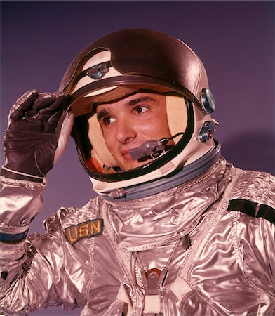 espaço sideral - 1960s MAN ASTRONAUT LIFTING UP VISOR HELMET WEARING SILVER NAVY SPACE SUIT Foto de stock - Direito Controlado, Número: 846-05646587