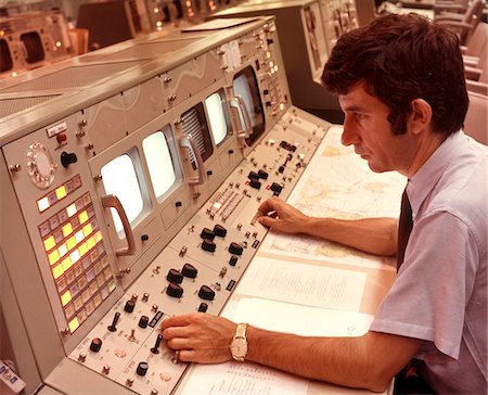 steuerung - 1970ER JAHRE MANN SITZT AM BEDIENFELD DES NASA MISSION CONTROL HOUSTON TEXAS USA Stockbilder - Lizenzpflichtiges, Bildnummer: 846-05646595