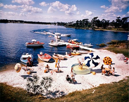 recreation usa - 1960s PEOPLE ON SMALL SANDY BEACH UMBRELLAS BOATS SUMMER FUN VACATION FLORIDA CYPRESS GARDENS Stock Photo - Rights-Managed, Code: 846-05646748