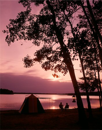 SILHOUETTE DES ANNÉES 1960 DU COUPLE CAMPING AU BORD DE LAC AU COUCHER DU SOLEIL Photographie de stock - Rights-Managed, Code: 846-05646768